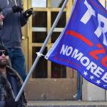 In this Nov. 7, 2020, photo Jaimie Sekona holds a Trump flag on the steps of the Alaska State Capitol. The former president is scheduled to speak Saturday afternoon at a rally in Anchorage. (Peter Segall / Juneau Empire File)