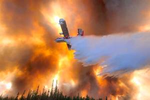 In this photo provided by Eric Kiehn, Northwest Incident Management Team 10, Alaska Division of Forestry, a fixed-wing aircraft drops water on the Clear Fire near Anderson, Alaska, July 6, 2022. One home has been destroyed by the wildfire burning in Alaskas interior, while a majority of people under evacuation orders are sheltering in place. (Eric Kiehn, Northwest Incident Management Team 10, Alaska Division of Forestry via AP)