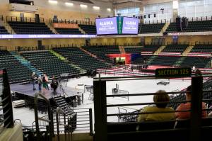 A couple of visitors watch preparations Friday afternoon for the Save America Rally scheduled Saturday at the Alaska Airlines Center in Anchorage. (Mark Sabbatini / Juneau Empire)
