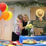 Vicke Kukowski (left) hugs Kathy Romain (right) after unveiling a plaque dedicating the Kenai Senior Centers greenhouse to Bill Osborn during a ceremony on Tuesday, July 12, 2022 in Kenai, Alaska. (Ashlyn OHara/Peninsula Clarion)
