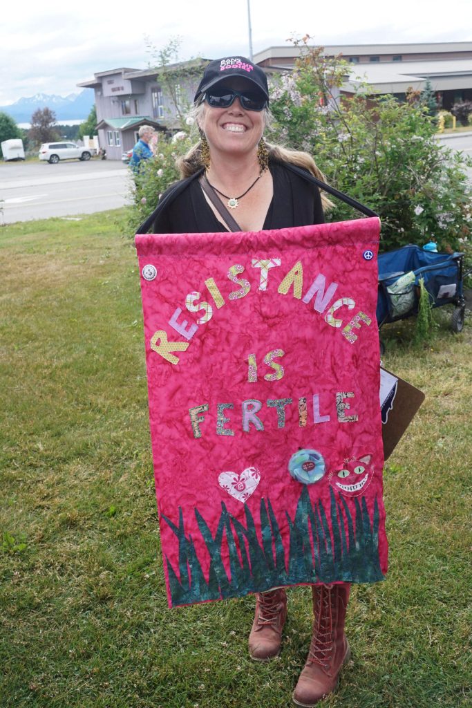 Carly Wier holds a sign that reads "Resistance is Fertile" at the "Women's March: Bans Off Our Bodies" protest on Saturday, July 9, 2022, at WKFL Park in Homer, Alaska. (Photo by Michael Armstrong/Homer News)