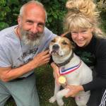 Greg and Teresa Groeneweg pose with their dog, Ace, who is wearing a lifesaver medal Greg received from the Anchorage Fire Department years ago. He said Ace deserves it now more than him, for fighting off a bear. (Courtesy Greg Groeneweg)