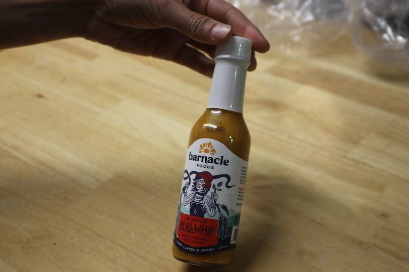 Barnacle Foods co-founder Lia Heifetz shows off a sauce made by the company. (Clarise Larson / Juneau Empire)