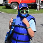 A boy fitted with a life jacket and waiting to go fishing at the Kenai River Junior Classic in Soldotna, Alaska, on Aug. 10, 2022. (Jake Dye/Peninsula Clarion)