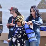 Summer Lazenby fits a child with a life jacket at the Kenai River Junior Classic in Soldotna, Alaska, on Aug. 10, 2022. (Jake Dye/Peninsula Clarion)