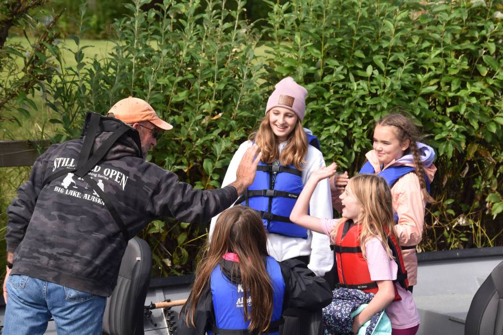 A fishing guide greets one of his passengers at the Kenai River Junior Classic in Soldotna, Alaska, on Aug. 10, 2022. (Jake Dye/Peninsula Clarion)