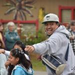 The head of a dance troupe leads both dancers and passerby in a flash mob style performance at the Kenai Peninsula Fair on Aug. 12, 2022, in Ninilchik, Alaska. (Jake Dye/Peninsula Clarion)