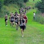 Kenai Central junior Greg Fallon takes the lead for good at the Kenai-Soldotna dual meet Monday, Aug. 15, 2022, at Tsalteshi Trails just outside of Soldotna, Alaska. (Photo by Jeff Helminiak/Peninsula Clarion)