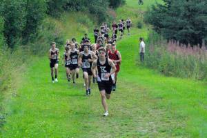 Kenai Central junior Greg Fallon takes the lead for good at the Kenai-Soldotna dual meet Monday, Aug. 15, 2022, at Tsalteshi Trails just outside of Soldotna, Alaska. (Photo by Jeff Helminiak/Peninsula Clarion)