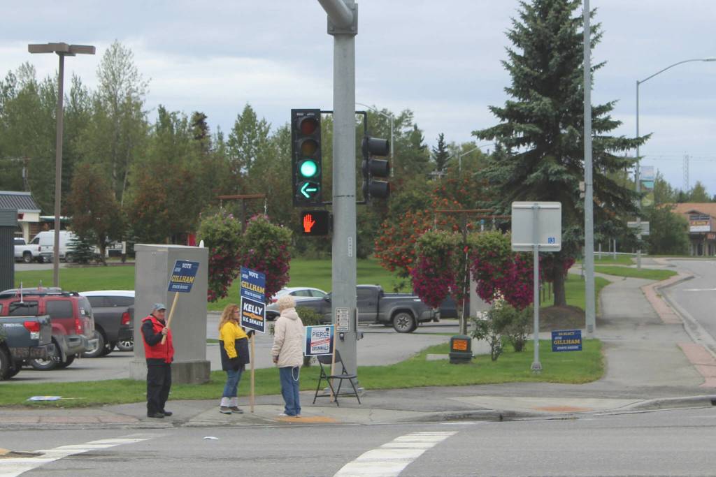 People wave signs supporting candidates at the intersection of the Kenai Spur and Sterling highways on Tuesday, Aug. 16, 2022 in Soldotna, Alaska. (Ashlyn OHara/Peninsula Clarion)