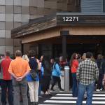 Members of the public and staff wait to enter the Kahtnuhtana Duhdeldiht Campus during an opening ceremony in Kenai, Alaska on Thursday, Sept. 1, 2022. (Jake Dye/Peninsula Clarion)