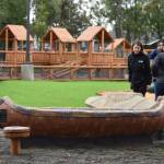 Members of a tour at the Kahtnuhtana Duhdeldiht Campus check out the birch bark canoe and kayak on the playground on Thursday, Sept. 1, 2022, in Kenai, Alaska. (Jake Dye/Peninsula Clarion)