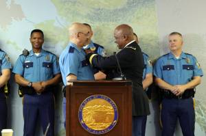 Alaska Defense Force Brig. Gen. Simon Brown pins a badge on Maurice Mo Hughes, left, who was promoted from commander of A Detachment to colonel of the Alaska State Troopers during a press conference on Wednesday, Aug. 31, 2022, in Anchorage, Alaska. (Photo courtesy Alaska State Troopers)