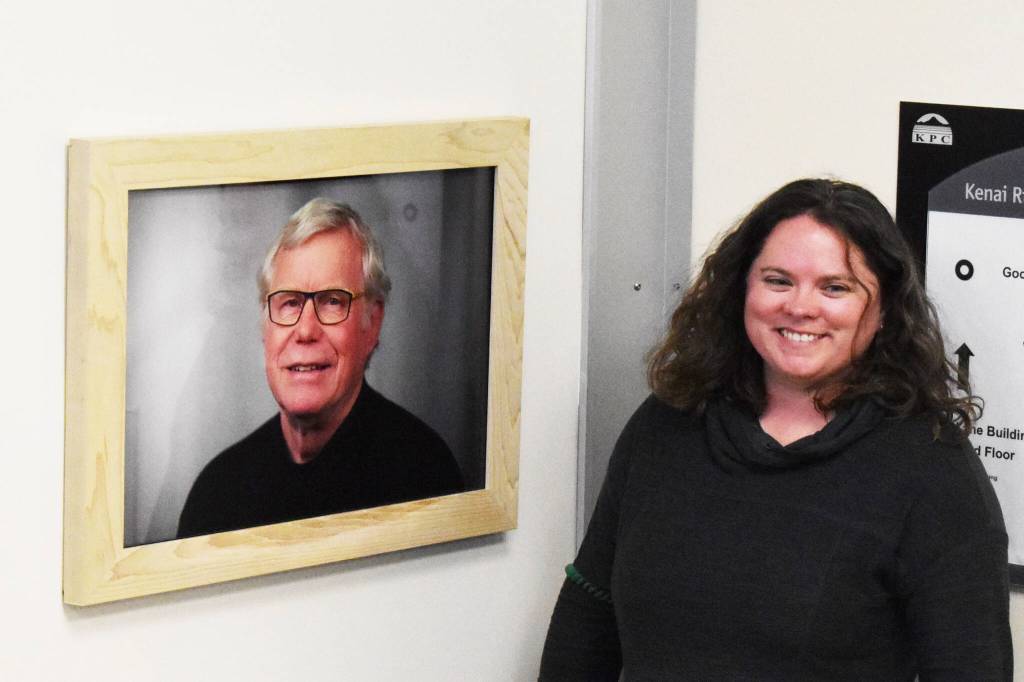 Kenai Peninsula College Advancement Programs Manager Alasha Brito unveils a new framed photo that hangs at the entryway of the newly dedicated Alan Tiqutsex Boraas Anthropology Lab at KPC on Friday, Sept. 16, 2022, in Soldotna, Alaska. A new plaque and a piece of artwork to commemorate Boraas also hang by the entryway. (Jake Dye/Peninsula Clarion)