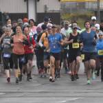 Marathon and half marathon runners begin the Kenai River Marathon on Sunday, Sept. 25, 2022, in Kenai, Alaska. At the front are womens marathon winner Amanda Cherok (28), mens half marathon winner Lee Frey (third from right), womens half marathon winner Kristin Davis (242) and mens marathon winner and new event record holder Lars Arneson (36).