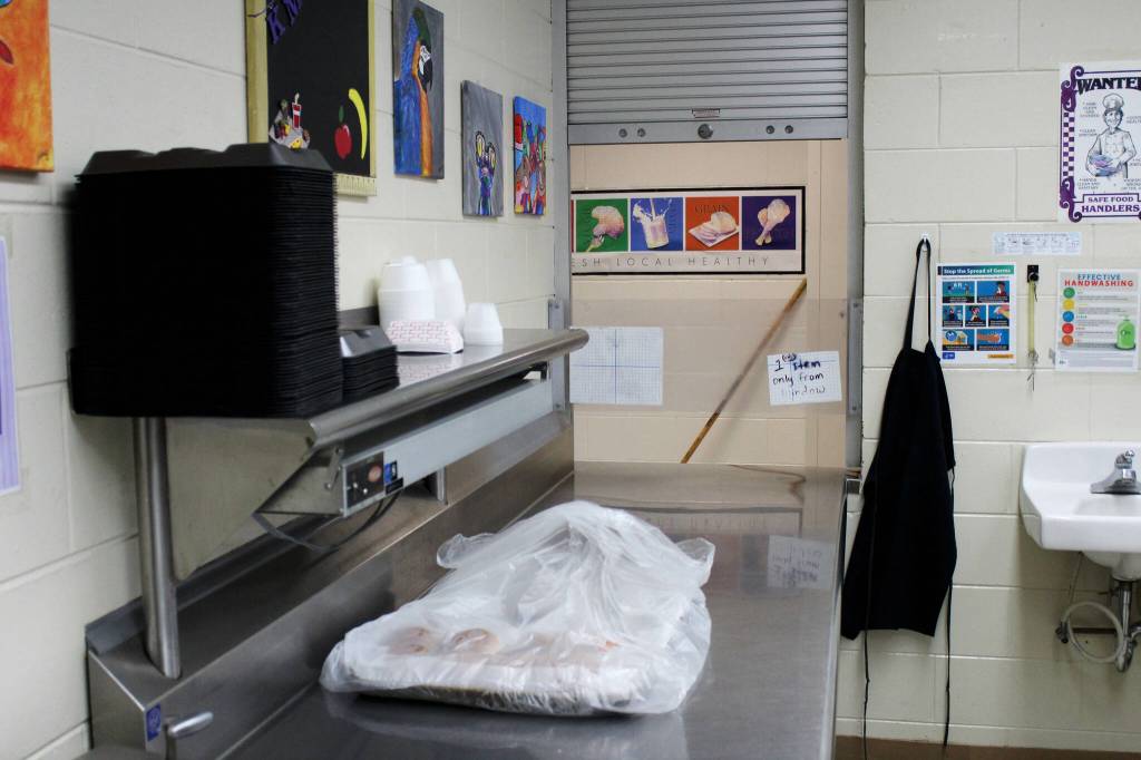 School lunch materials sit on a prep table near the cafeteria window inside the Kenai Middle School kitchen on Wednesday, Sept. 21, 2022, in Kenai, Alaska. A bond package up for consideration by voters next month would fund the expansion of the schools kitchen in addition to other projects. (Ashlyn OHara/Peninsula Clarion)