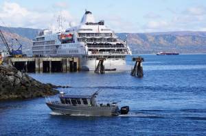 A fishing boat passes the Silversea cruise ship Silver Wind as the boat enters the Homer Harbor on Sunday, Sept. 25, 2022, in Homer, Alaska. (Photo by Michael Armstrong/Homer News)