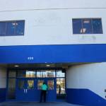 Principal Sarge Truesdell unlocks a door at Soldotna High School underneath cracked siding on Tuesday, Sept. 27, 2022, in Soldotna, Alaska. The siding is one of several projects in a bond package Kenai Peninsula voters will consider during the Oct. 4 municipal election. (Ashlyn OHara/Peninsula Clarion)