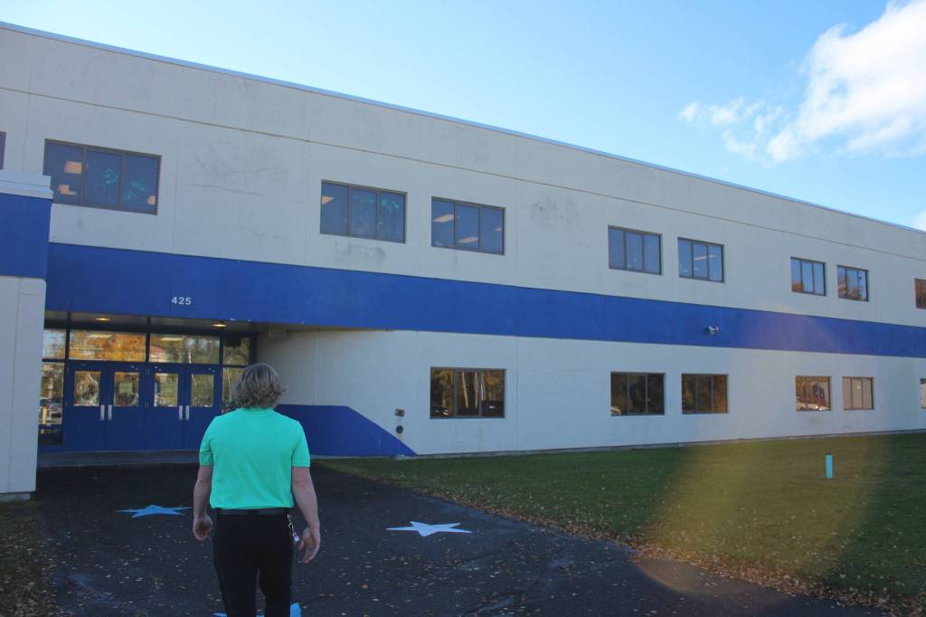 Principal Sarge Truesdell looks at cracked siding outside of Soldotna High School on Tuesday, Sept. 27, 2022, in Soldotna, Alaska. The siding is one of several projects in a bond package Kenai Peninsula voters will consider during the Oct. 4 municipal election. (Ashlyn OHara/Peninsula Clarion)