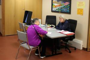 Carol Freas (right) helps a voter fill out absentee election materials in Kenai City Hall ahead of the Oct. 4 municipal election on Thursday, Sept. 29, 2022 in Kenai, Alaska. (Ashlyn OHara/Peninsula Clarion)