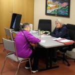 Carol Freas (right) helps a voter fill out absentee election materials in Kenai City Hall ahead of the Oct. 4 municipal election on Thursday, Sept. 29, 2022 in Kenai, Alaska. (Ashlyn OHara/Peninsula Clarion)