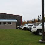 Staff vehicles are parked on the grass behind Mountain View Elementary School on Thursday, Sept. 29, 2022 in Kenai, Alaska. A bond package up for consideration by Kenai Peninsula Borough voters on Oct. 4 would fund improvements to the schools traffic flow. (Ashlyn OHara/Peninsula Clarion)