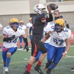 Kenai Centrals Bridger Beck passes under pressure from Barrows Lennox Dias and Norm Lilomaiava on Saturday, Oct. 1, 2022, at Ed Hollier Field at Kenai Central High School in Kenai, Alaska. (Photo by Jeff Helminiak/Peninsula Clarion)