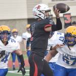 Kenai Central's Bridger Beck passes under pressure from Barrow's Lennox Dias and Norm Lilomaiava on Saturday, Oct. 1, 2022, at Ed Hollier Field at Kenai Central High School in Kenai, Alaska. (Photo by Jeff Helminiak/Peninsula Clarion)
