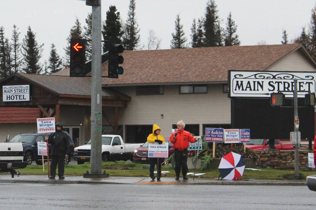 People waive political signs at the intersection of Bridge Access Road and the Kenai Spur Highway on Tuesday, Oct. 4, 2022, in Kenai, Alaska. (Ashlyn OHara/Peninsula Clarion)