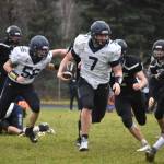 Homers Carter Tennison runs with the ball, pursued by several Bulldogs, during the playoff game on Saturday, Oct. 8, 2022, at Nikiski Middle/High School in Nikiski, Alaska. (Jake Dye/Peninsula Clarion)