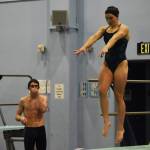 Abriella Werner leaps as she approaches the end of the diving board, Derrick Jones watches during a dive practice on Tuesday, Oct. 11, 2022, at Soldotna High School in Soldotna, Alaska. (Jake Dye/Peninsula Clarion)