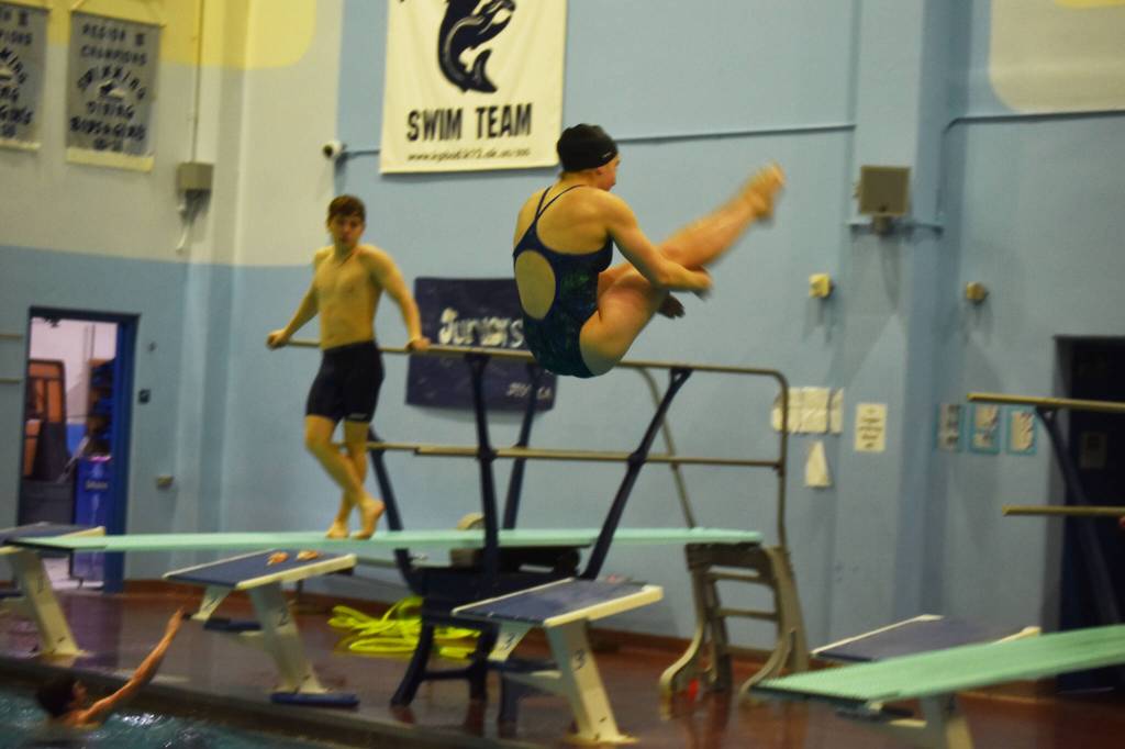 Abriella Werner performs a reverse dive during a practice on Tuesday, Oct. 11, 2022 at Soldotna High School in Soldotna, Alaska. (Jake Dye/Peninsula Clarion)