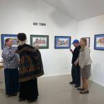 A community member discusses the exhibit with artist Teresa Aldridge while collaborating artist Erik Behnke and his mother, Linda Thomspon, look on, Friday, Oct. 7, 2022, in Homer, Alaska. (Photo by Christina Whiting/Homer News)