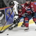 Kenai Rivers Hayden Walters battles for the puck with Davis Ormins and Sam Berry of the Fairbanks Ice Dogs on Friday, Oct. 14, 2022, at the Soldotna Regional Sports Complex in Soldotna, Alaska. (Photo by Jeff Helminiak/Peninsula Clarion)