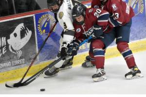 Kenai River's Hayden Walters battles for the puck with Davis Ormins and Sam Berry of the Fairbanks Ice Dogs on Friday, Oct. 14, 2022, at the Soldotna Regional Sports Complex in Soldotna, Alaska. (Photo by Jeff Helminiak/Peninsula Clarion)