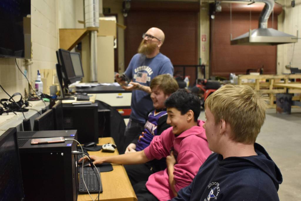 From left, Coach Jonus Kaponus Angleton, Bryce LeFevre, Dalton Schanrock and Graehm LeFevre celebrate victory during SoHi's Rocket League match against Thunder Mountain High School on Thursday, Oct. 20, 2022 at Skyview Middle School in Soldotna, Alaska. (Jake Dye/Peninsula Clarion)