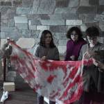 Teens search a piece of  fake  bloodied gauze for the pieces to a combination in an escape room on Oct. 21, 2022, at Soldotna Public Library in Soldotna, Alaska. (Jake Dye/Peninsula Clarion)