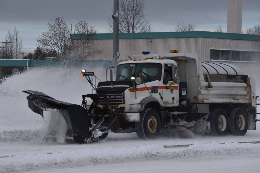 A plow truck clears snow as it moves down the Kenai Spur Highway in Kenai, Alaska on Wednesday, Oct. 26, 2022. (Jake Dye/Peninsula Clarion)