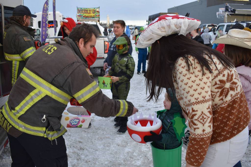 Central Emergency Services staff hand candy to kids at the Orca Theaters Trunk or Treat in Soldotna, Alaska, on Monday, Oct. 31, 2022. (Jake Dye/Peninsula Clarion)