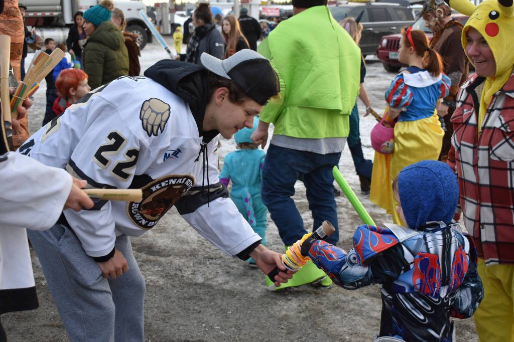 Ashton Christman hands out glow bracelets at the Orca Theaters Trunk or Treat in Soldotna, Alaska on Monday, Oct. 31, 2022. (Jake Dye/Peninsula Clarion)