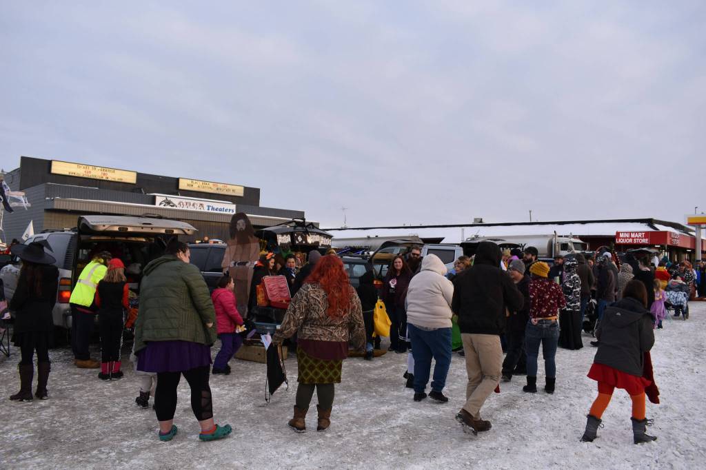Families, kids and other costumed individuals move from car to car collecting candy at the Orca Theaters Trunk or Treat in Soldotna, Alaska, on Monday, Oct. 31, 2022. (Jake Dye/Peninsula Clarion)