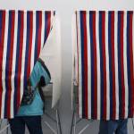 Two residents stand in voter booths on the first day of early and absentee in-person voting across the state for the Nov. 8 general election. Recent filings for candidates in statewide races shows spending ramping up as the big day approaches. (Clarise Larson / Juneau Empire File)