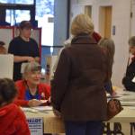 Kit Hill checks in a voter at the Kenai Mall, voting place for Kenais Precinct #1 in Kenai, Alaska on Election Day, Nov. 8, 2022. (Jake Dye/Peninsula Clarion)