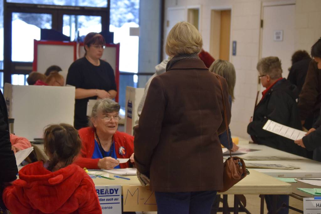 Kit Hill checks in a voter at the Kenai Mall, voting place for Kenais Precinct #1 in Kenai, Alaska on Election Day, Nov. 8, 2022. (Jake Dye/Peninsula Clarion)