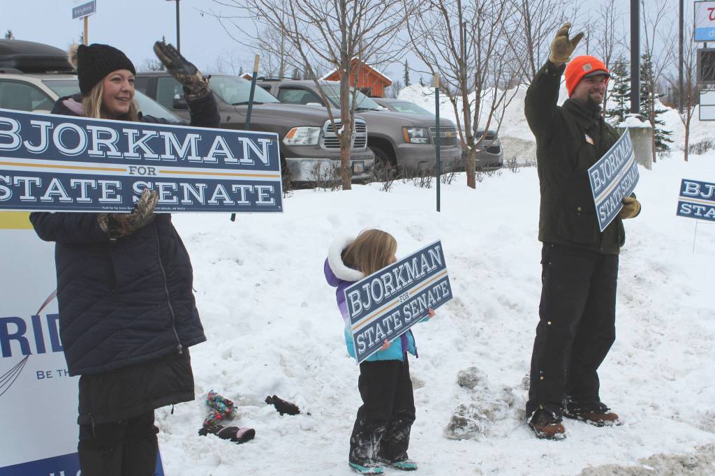 From left, Jamie, Brinna and Jesse Bjorkman wave signs supporting Jesse Bjorkmans bid for Alaska State Senate at the intersection of the Kenai Spur and Sterling highways on Tuesday, Nov. 8, 2022 in Soldotna, Alaska. (Ashlyn OHara/Peninsula Clarion)