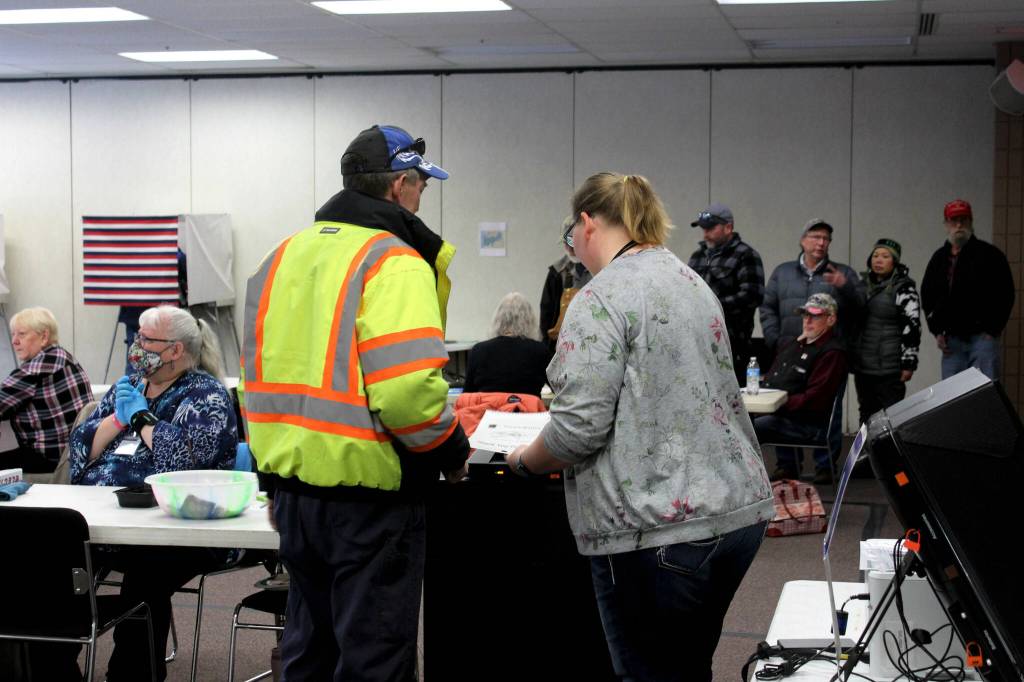 Poll worker Harmony Bolden (right) helps a voter cast their ballot at the Soldotna Regional Sports Complex on Tuesday, Nov. 8, 2022 in Soldotna, Alaska. (Ashlyn OHara/Peninsula Clarion)