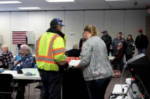 Poll worker Harmony Bolden, right, helps a voter cast their ballot at the Soldotna Regional Sports Complex on Tuesday, Nov. 8, 2022, in Soldotna, Alaska. (Ashlyn OHara/Peninsula Clarion)