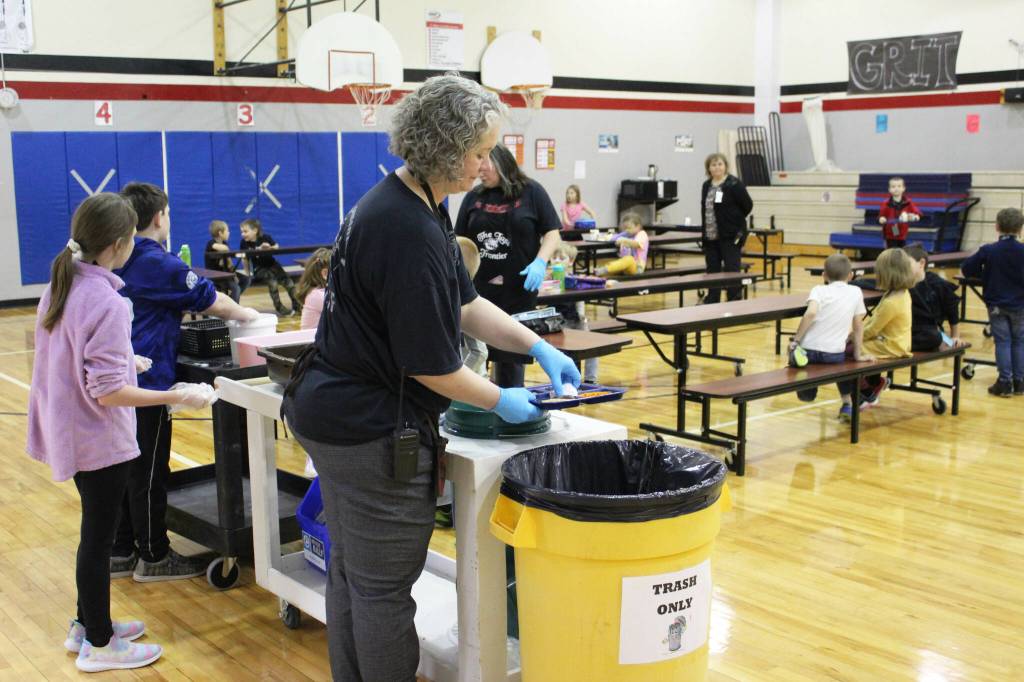Principal Denise Kelly helps students dispose of lunch materials at Sterling Elementary School on Thursday, Nov. 10, 2022, in Sterling, Alaska. (Ashlyn OHara/Peninsula Clarion)