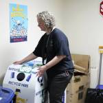 Principal Denise Kelly adjusts recycling receptacles at Sterling Elementary School on Thursday, Nov. 10, 2022, in Sterling, Alaska. (Ashlyn OHara/Peninsula Clarion)