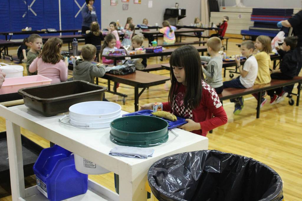 Grecia Martinez Sandstrom, second grade, disposes of lunch materials at Sterling Elementary School on Thursday, Nov. 10, 2022, in Sterling, Alaska. (Ashlyn OHara/Peninsula Clarion)